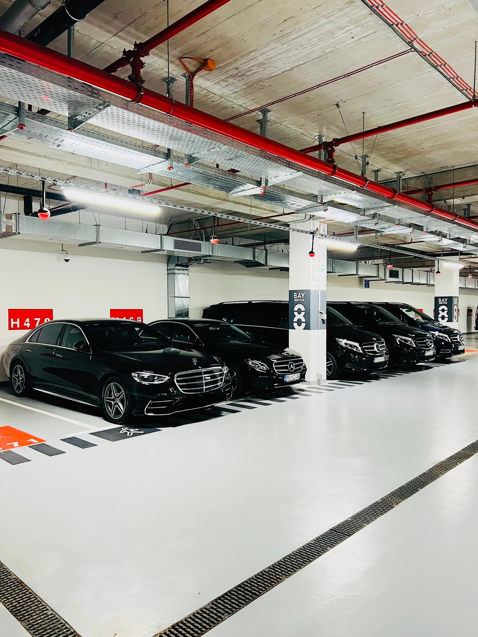 Black Mercedes-Benz cars and vans parked in an indoor garage bay