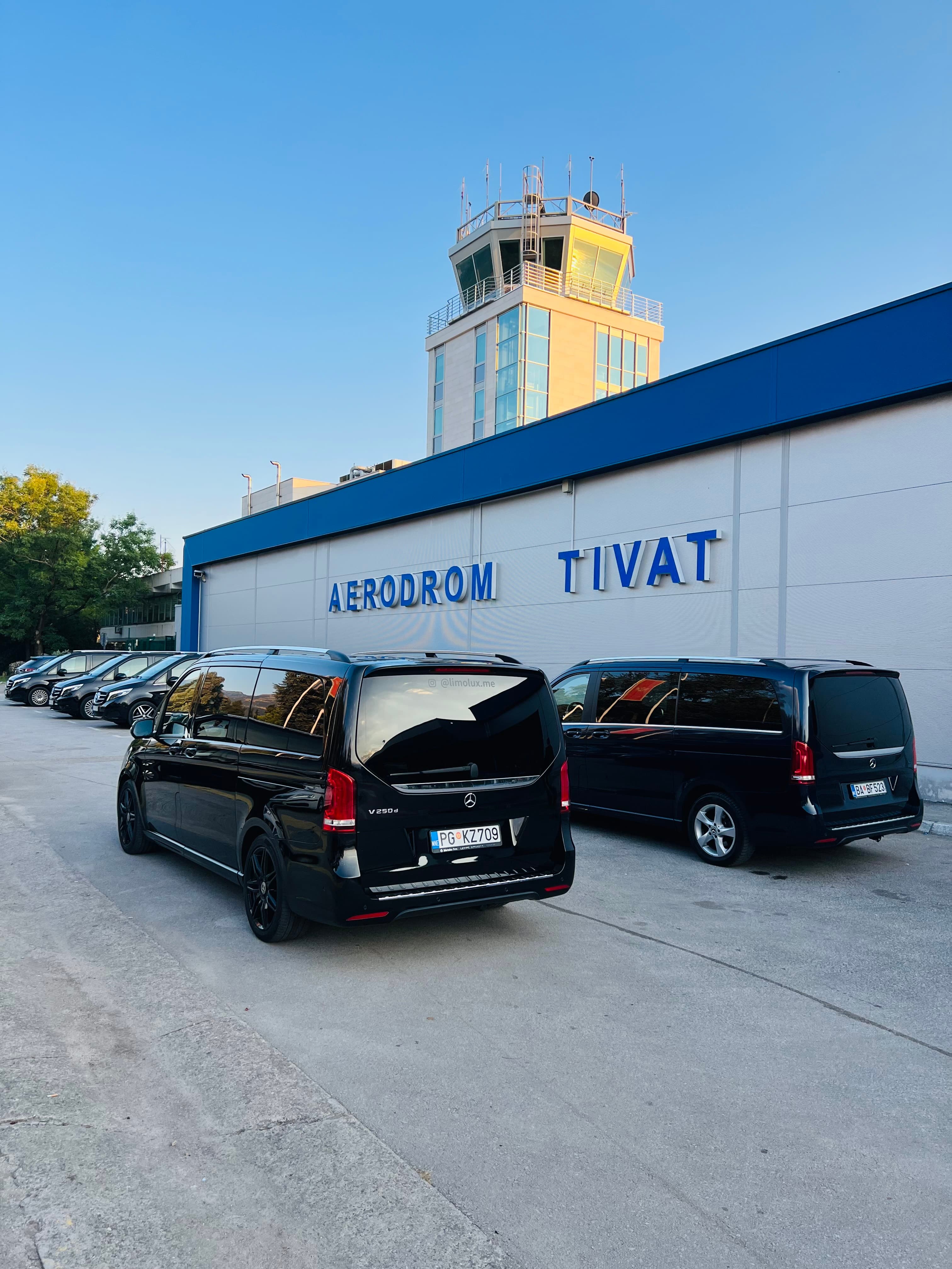 Black Mercedes-Benz vans parked in front of Tivat Airport terminal